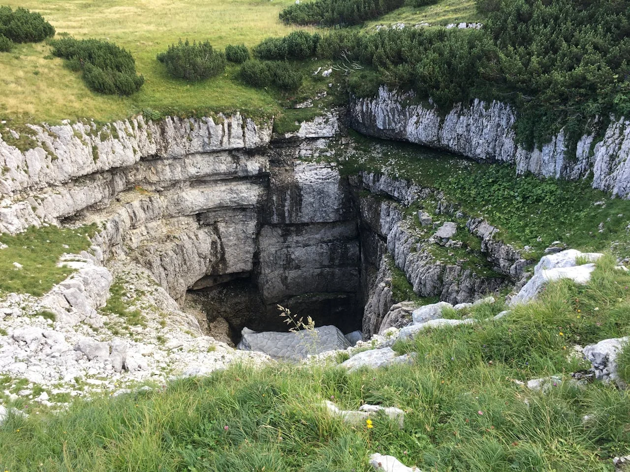 Giant sinkhole swallowing part of a grassy landscape, showing the type of unexpected disasters Clay Travis Law helps families recover from.