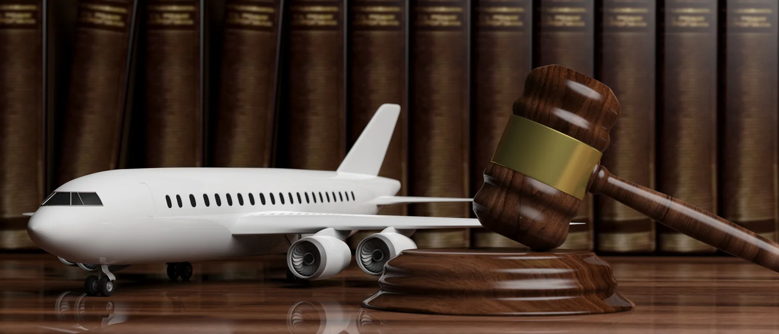 Model airplane placed next to a courtroom gavel, symbolizing the aviation accident cases Clay Travis Law fights for across the South.